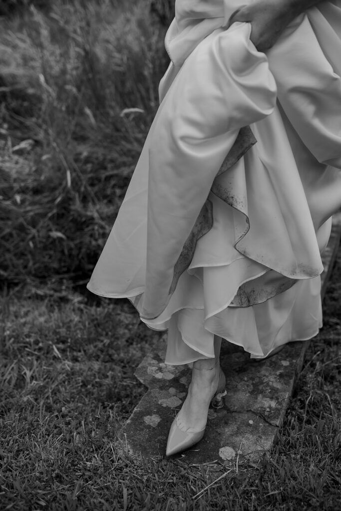 Artistic close-up of bride’s dress and shoes slightly dirtied from the mud of her Southern Highlands wedding